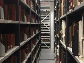 archival boxes stacked in two floor to ceiling shelves in the LSE basement
